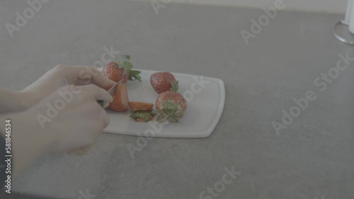 female hands cutting strawberries. shot in slog 3 photo