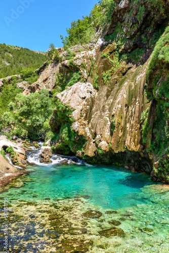 Beautiful creek and turquoise natural pool under rocky cliff at Krcic waterfall near Knin, Croatia