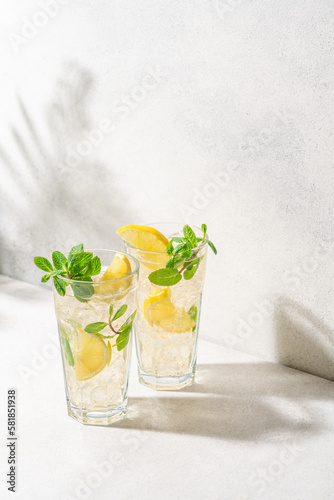 Refreshing drink with ice, lemon and mint. Cold lemonade on white background