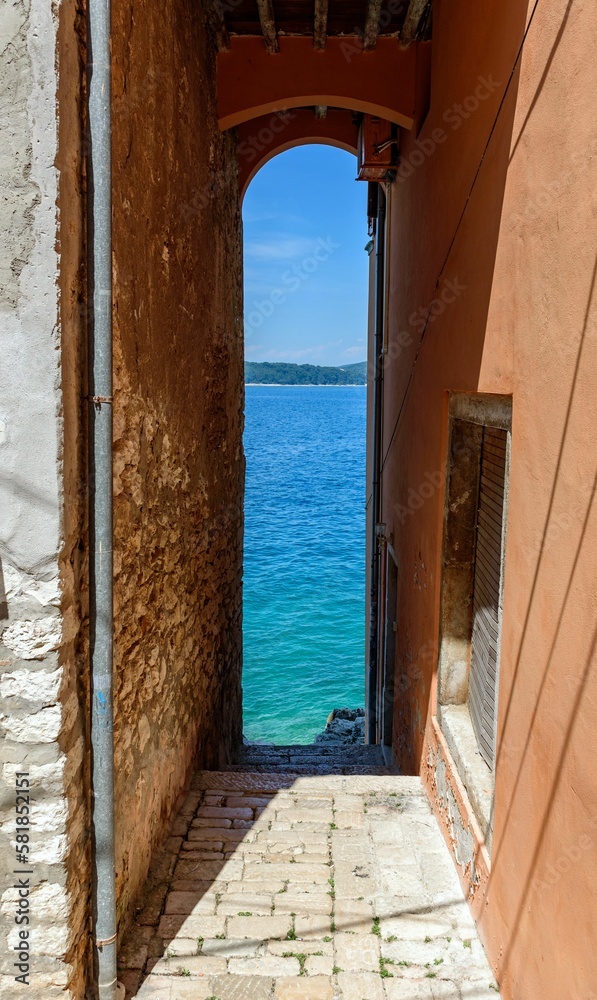 Vertical shot of a narrow alley leading to sea in Rovinj, Croatia Vertical shot of a narrow alley leading to sea in Rovinj, Croatia