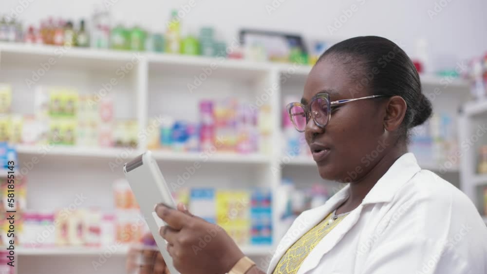 Telehealth, Black African Female Pharmacist using Smart Tablet to show remote patient, available drugs medicine in pharmacy on video call. Telehealth, Black African Female Pharmacist using Smart Tablet to show remote patient, available drugs medicine in pharmacy on video call.