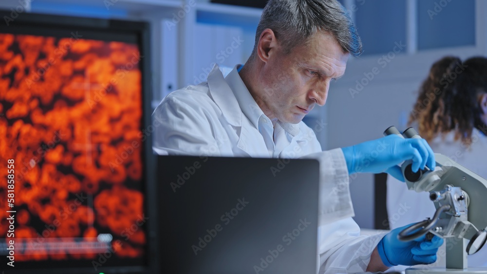 Scientist adjusting microscope to examine blood sample, diagnostics and treatment Scientist adjusting microscope to examine blood sample, diagnostics and treatment