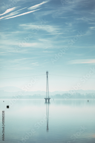 Power line tower in the middle of calm Ptuj lake.