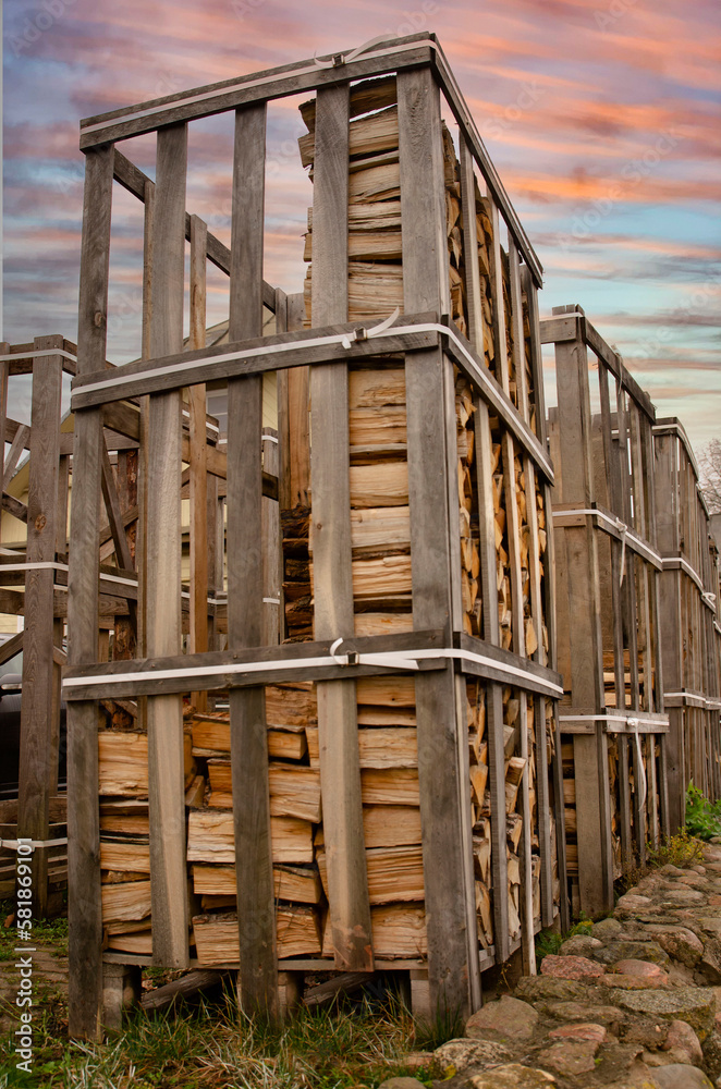 firewood stacked in a container against the backdrop of the setting sun portrait orientation firewood stacked in a container against the backdrop of the setting sun portrait orientation