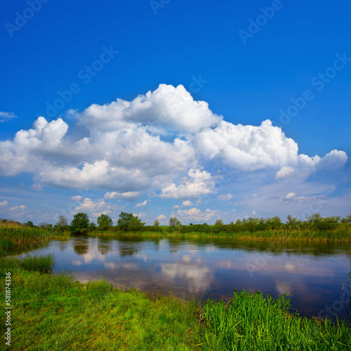 small calm river under blue cloudy sky at the sumer day