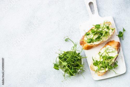 Toast with cream cheese and micro greens. Healthy food, vegetarian dish. Flat lay on white.