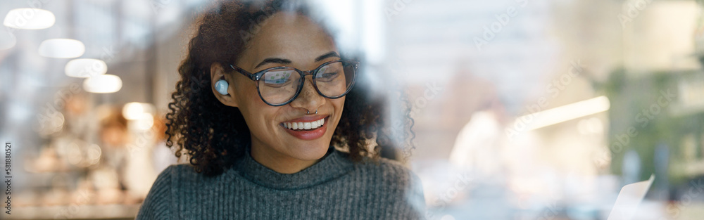 Smiling woman freelancer working laptop and making notes while sitting near windows in cozy cafe Smiling woman freelancer working laptop and making notes while sitting near windows in cozy cafe