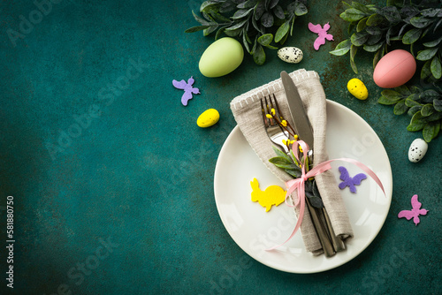 Easter food background. Spring table setting. White plate with cutlery easter decor. Flat lay with copy space.