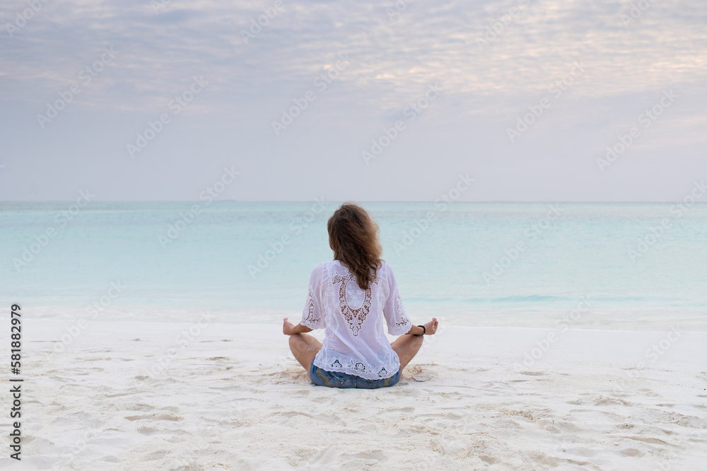 woman in meditation posture by the sea woman in meditation posture by the sea