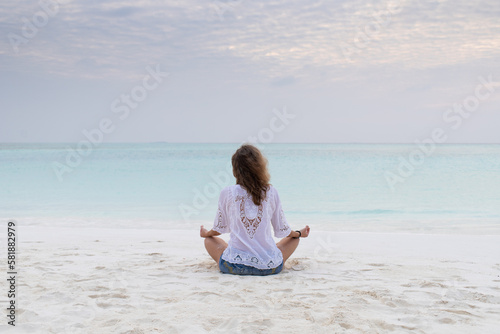 woman in meditation posture by the sea
