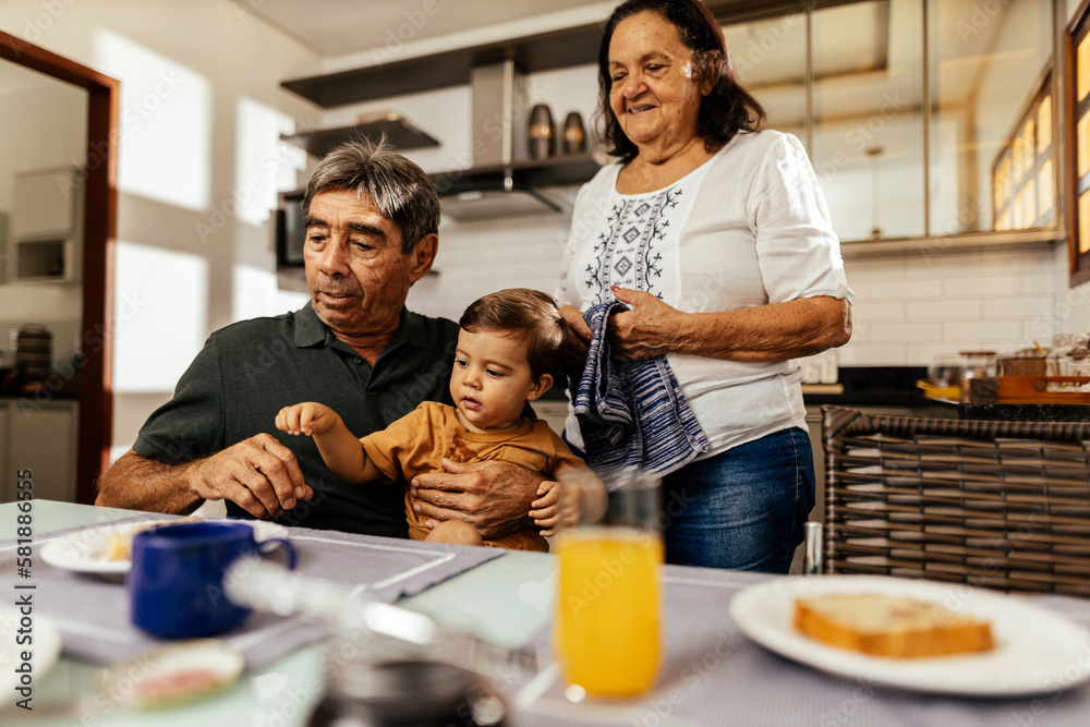 Happy grandparents having breakfast with their grandson