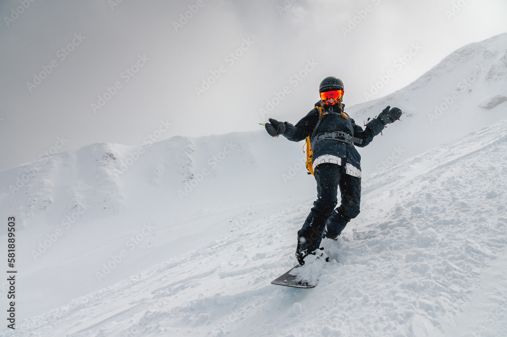 snowboarder bent over and brakes on a freeride slope. Active man snowboarder rides on the slope. ski resort