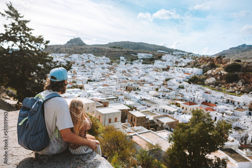 Family father and child traveling in Rhodes island, Greece sightseeing Lindos city white houses aerial view summer vacations lifestyle Europe destinations photo