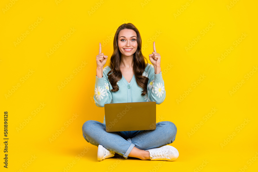 Full length photo of pretty shiny lady dressed teal cardigan chatting gadget pointing up empty space isolated yellow color background