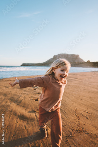 Happy child girl playing on beach emotional kid 4 years old family travel lifestyle summer vacations outdoor