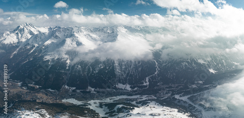 Alpine landscape with peaks covered by snow and clouds. Magical clouds covering peaks of the mountains at the famous St. Anton am Arlberg ski resort. © Aerial Film Studio