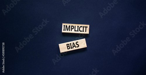 Implicit bias symbol. Concept words Implicit bias on wooden block. Beautiful black table black background. Business psychology implicit bias concept. Copy space.