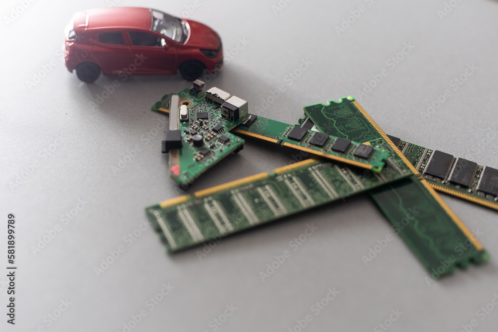 Toy cars on an electronic board with integrated circuits. The shortage of microchips and semiconductors creates a shortage of new cars. semiconductor shortage concept. Toy cars on an electronic board with integrated circuits. The shortage of microchips and semiconductors creates a shortage of new cars. semiconductor shortage concept.