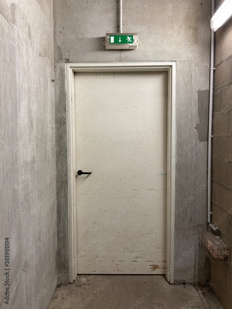 1 door in a basement with concrete walls and breeze blocks.