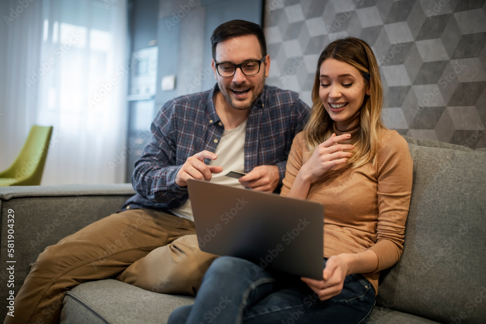 Couple using laptop in living room Couple using laptop in living room