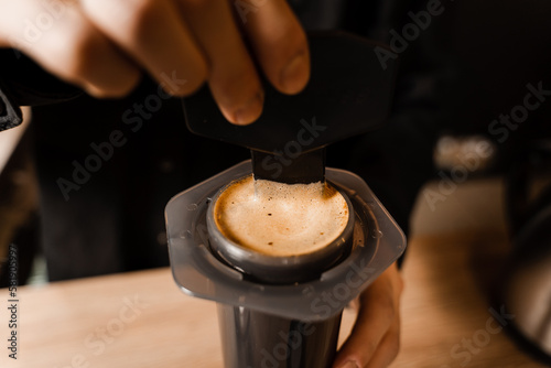 Close-up barista brews Aeropress coffee and stirs it inside. Process of aeropress alternative method brewing coffee.