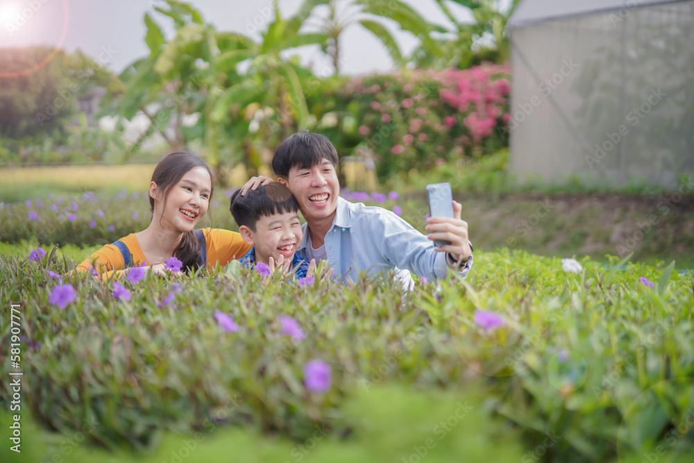 Mom som and dad, happy family taking selfie together at flower farm, relationship in family while travelling concept.