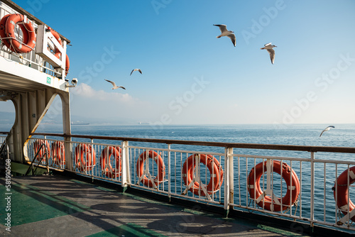 a landscape from the ferry in daylight with the sky sea and seagulls on the background , space for text ,  photo