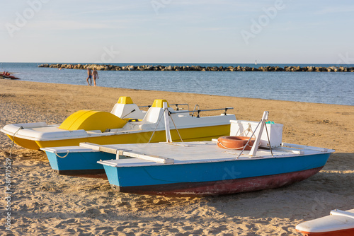 Yellow vintage plastic catamaran and wood boat shore of sea for water activities during vacation.