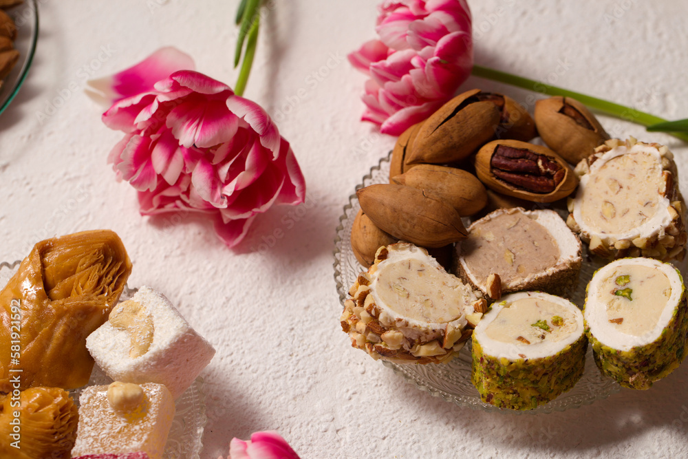 Still life of Delicious oriental desserts on a light background with pink tulips