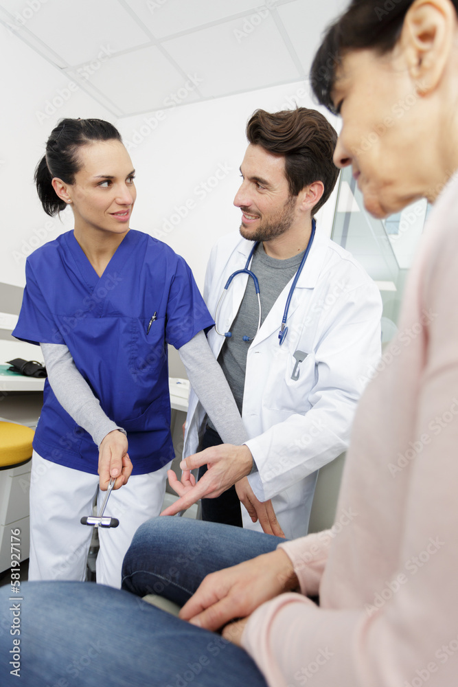 Obraz premium nurse trains to test knee reflexes on patient
