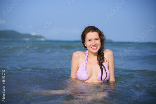 Portrait of happy positive girl  young woman swimming in sea or ocean  enjoying summer vacation  smile  laugh  have fun in water 
