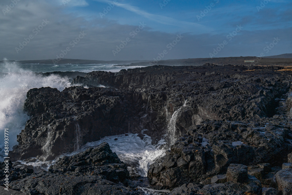 Fototapeta premium Black rocks on the coast of Iceland with big waves