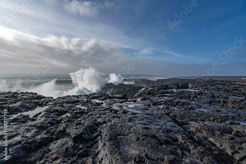 Black rocks on the coast of Iceland with big waves