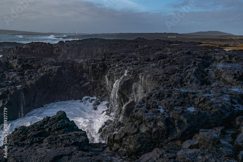Black rocks on the coast of Iceland with big waves