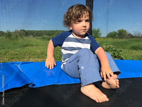 curly cute baby resting on a trampoline