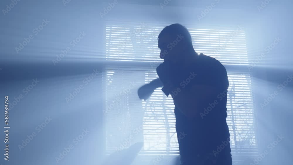 Boxer trains in the hall. Silhouette of an athlete fighting with a shadow. The athlete is preparing for the fight. High quality 4k footage Boxer trains in the hall. Silhouette of an athlete fighting with a shadow. The athlete is preparing for the fight. High quality 4k footage