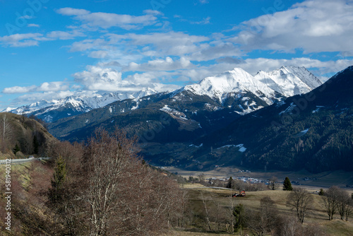 Snowy mountain peaks and valleys with trees and meadows in winter in Austria.