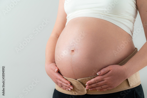 Orthopedic belt on a pregnant girl supports the stomach and helps with back pain