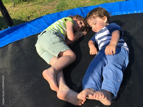 two brothers play and rest sleep and lie on the trampoline