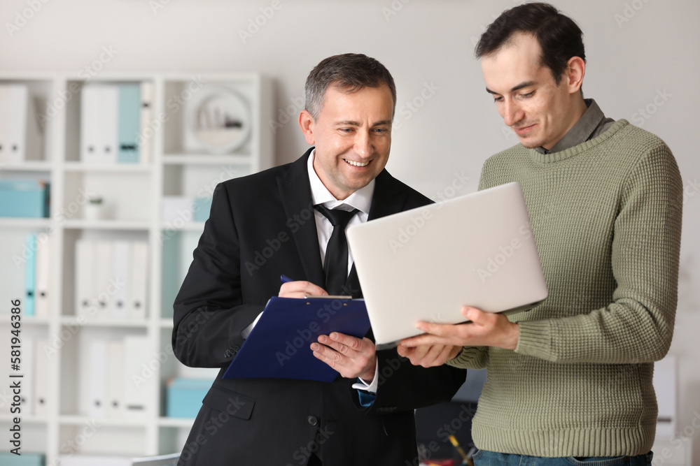 Mature accountant working with his colleague in office Mature accountant working with his colleague in office