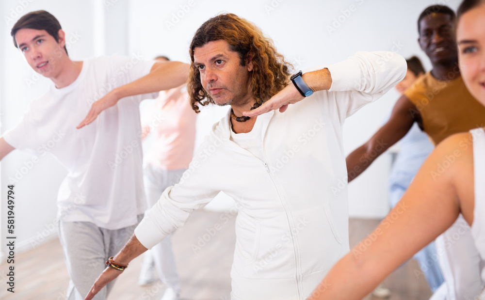 Fototapeta premium Adult positive man learning dance in dance studio