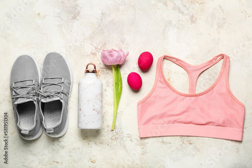 Sportswear with bottle, flower and Easter eggs on grunge background