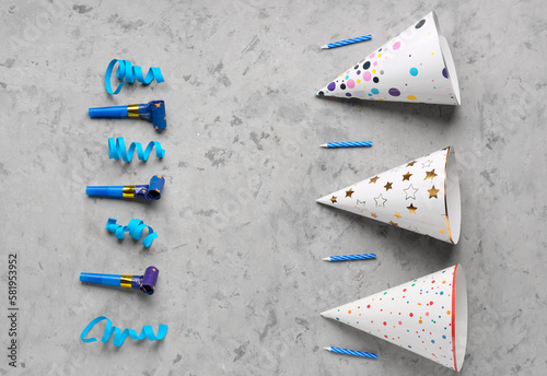 Composition with party hats, whistles, birthday candles and serpentine on grunge background