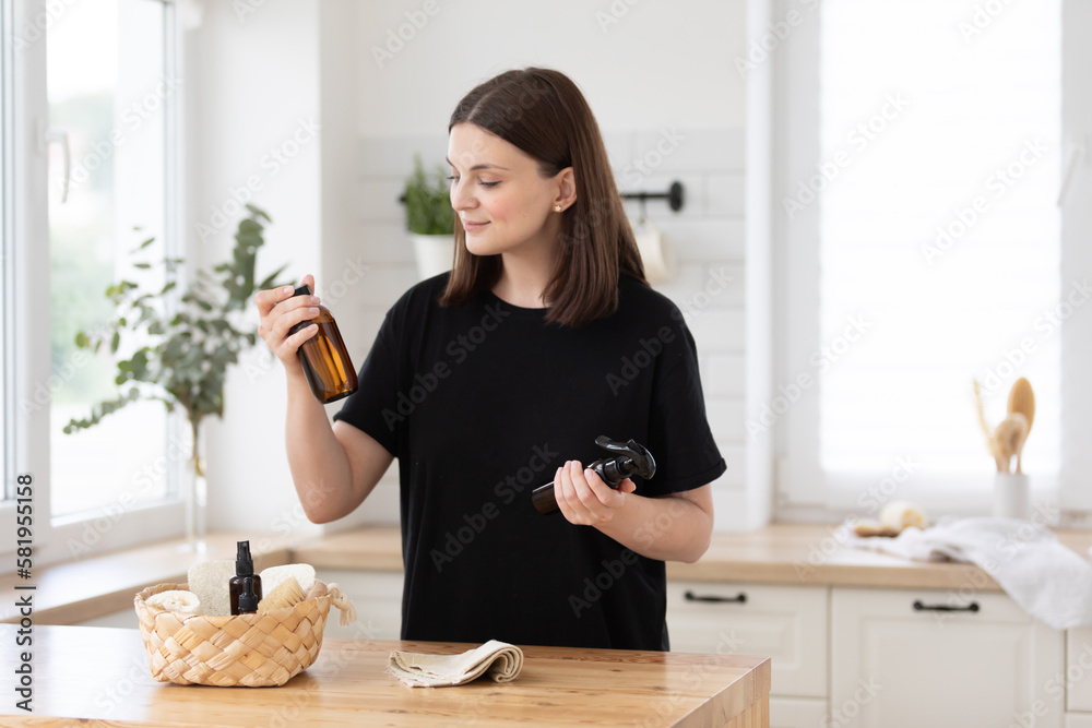 Young woman cleans the kitchen with eco products.