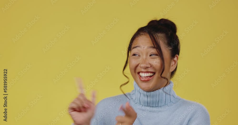 Asian woman, smile and portrait or pointing hands in studio on a yellow background isolated space. Female model person happy with product placement, marketing or funny announcement with finger guns Asian woman, smile and portrait or pointing hands in studio on a yellow background isolated space. Female model person happy with product placement, marketing or funny announcement with finger guns