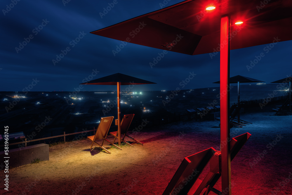 Fototapeta premium Umbrellas at the viewpoint of the Hambach brown coal mine at night, in Elsdorf, Germany