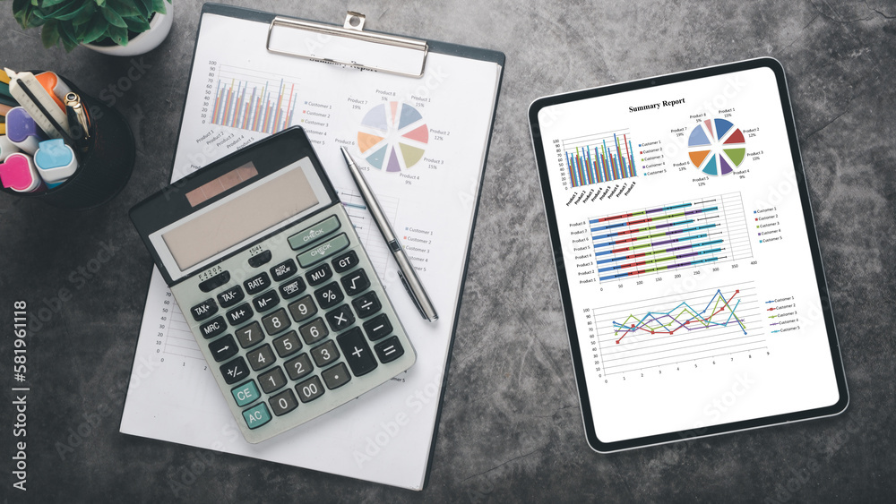 Obraz premium Tablet with charts and reports on office desk workplace. Top view flat lay.