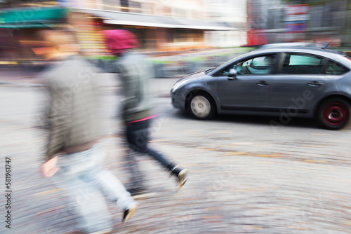 abstract blurred image of a walking couple and driving car