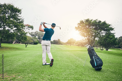 Golf, stroke and training with a sports man swinging a club on a field or course for recreation and fun. Golfing, grass and hobby with a male golfer playing a game on a green during summer