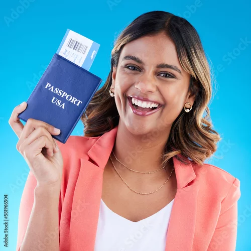 Obraz Passport, excited and woman portrait isolated on blue background for USA travel opportunity, immigration or holiday. Identity documents, flight ticket and happy face of young indian person in studio